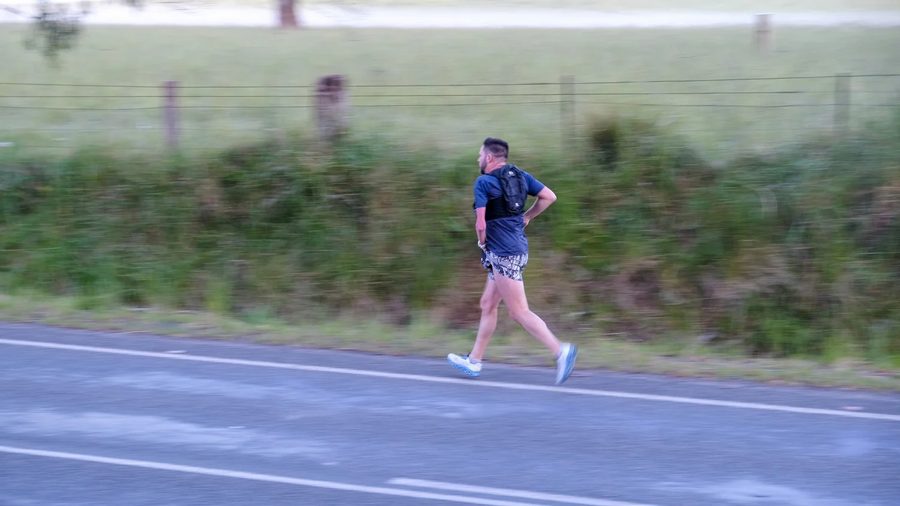 Rodney running through a country town on a multi-day challenge